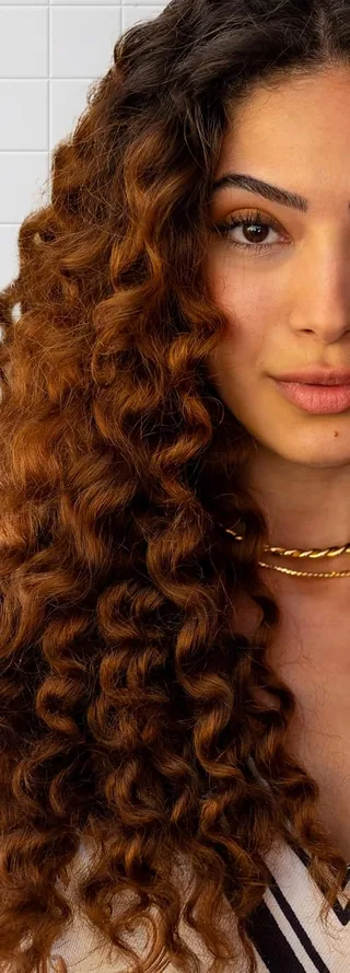 A woman with long auburn curls