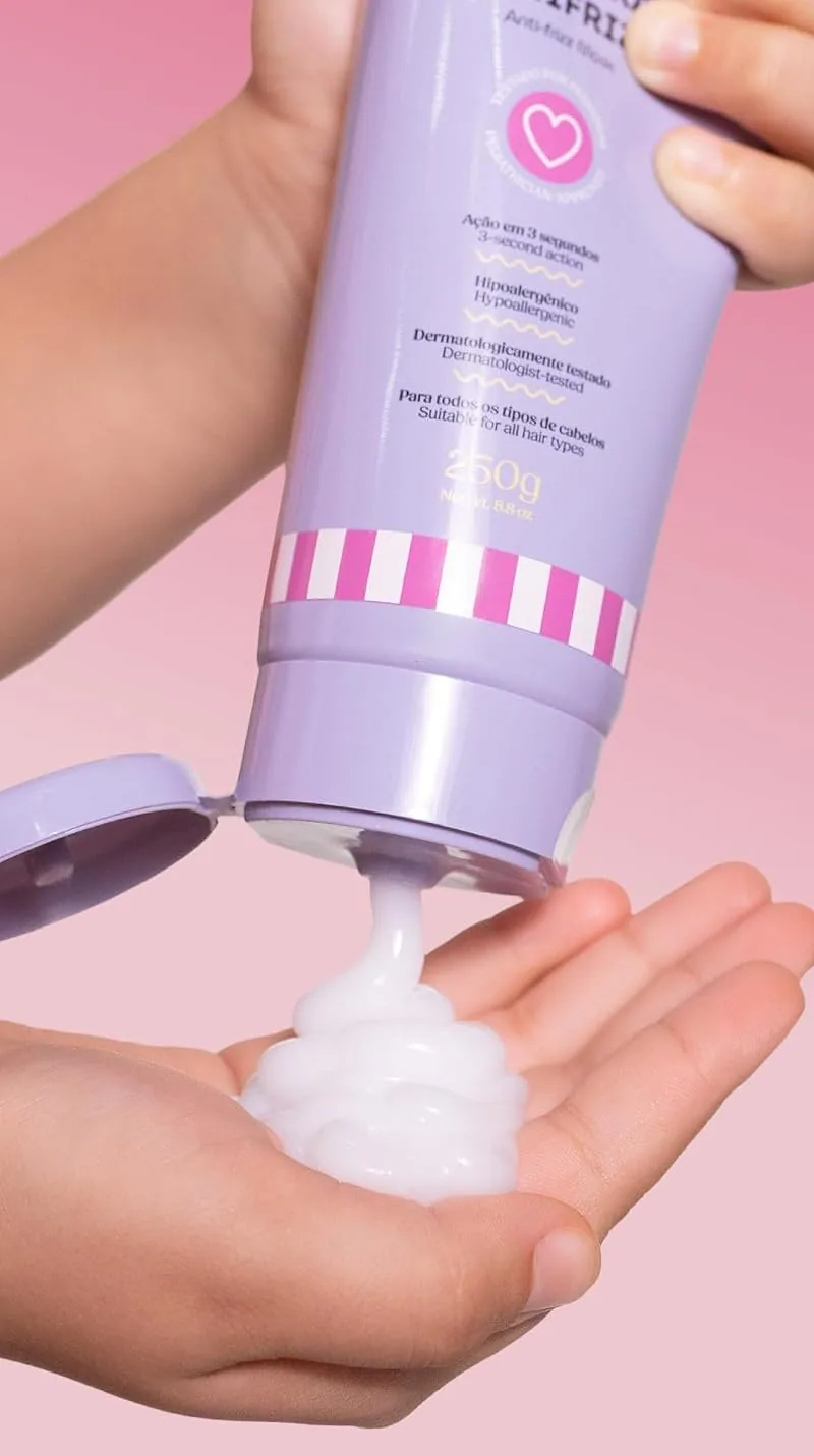 A child's hands squeezing the lilac kids' mask tube into a palm