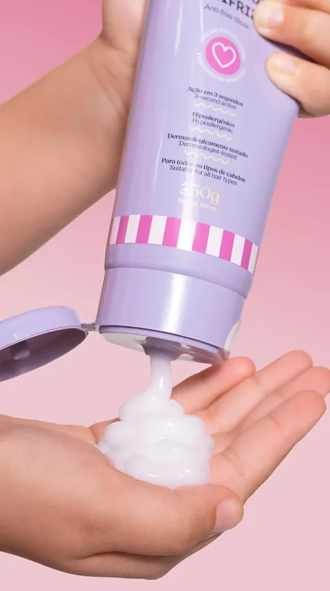 A child's hands squeezing the lilac kids' mask tube into a palm